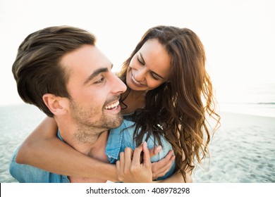 Boyfriend giving piggy back to girlfriend on a sunny day - Shutterstock ID 408978298