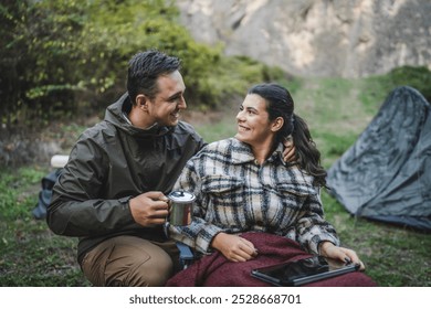 boyfriend take care of his girlfriend and share tea with her on camping trip - Powered by Shutterstock