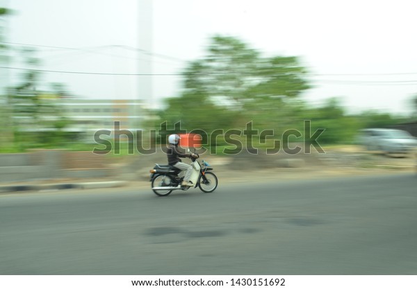 boyolali, indonesia - june 7, 2019 : motor\
vehicle on boyolali streets in motion. Blurred picture technique\
long exposure or technique\
panning.