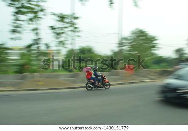 boyolali, indonesia - june 7, 2019 : motor\
vehicle on boyolali streets in motion. Blurred picture technique\
long exposure or technique\
panning.