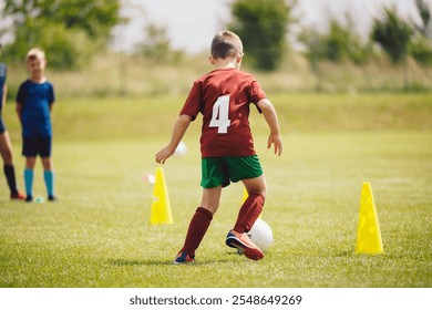 Boys attending soccer training on school field. Young man coaching children on physical education class. Soccer practice for children - Powered by Shutterstock