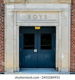 'Boys' concrete exterior entrance to an old school building with red brick walls. - Powered by Shutterstock