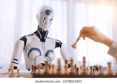 The boy's determination shows as he plays chess with a robot.