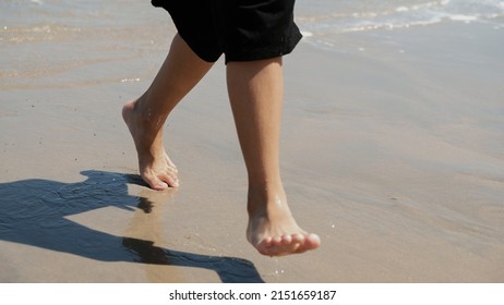 Boy's Feet Running On The Beach