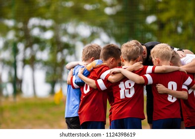 Boys Football Team With Coach. Youth Soccer Team Huddle With Coach. Motivation Talk, Pep Talk Before The Match. Young Football Soccer Players In Jersey Colorful Sportswear