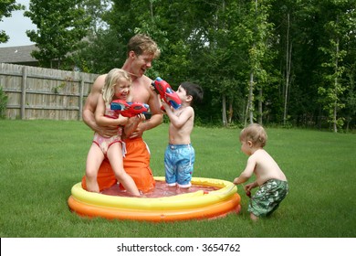 Boys And Girl Play With Dad In The Kiddie Pool