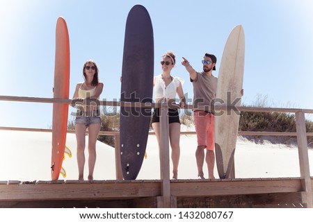 Similar – Young friends holding woman on top of surfboard