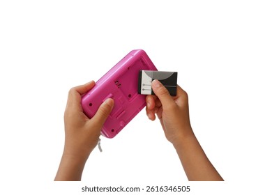 A boy's hand is gesturing to insert a battery into an MP3 player.
