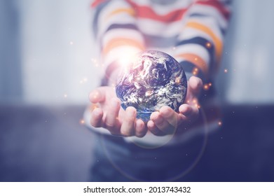boy's hand holding a globe, The globe in children's hands. Concept for environment conservation. Elements of this image furnished by NASA - Shutterstock ID 2013743432