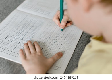 Boy's hands close up. School boy going homework at home, writing in notebook. - Powered by Shutterstock