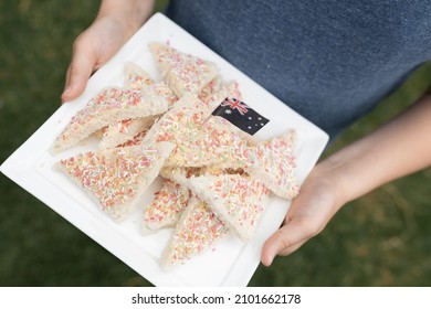 A Boy's Hands Holding A Plate With The Traditional Australian Party Food Fairy Bread On It With The Aussie Flag Stuck Into The Bread