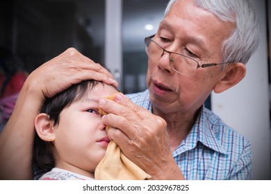 Boy's Head Hurts, Father Wraps Ice Cubes In A Towel And Puts A Cold Compress On His Son. First Aid.