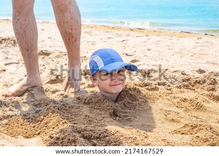 Similar – Image, Stock Photo Small child buried in the sand of the beach