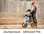 Boys in the image of a rider and a rocketman play in the backyard of the house