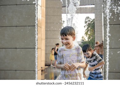 Boys jumping in water fountains. Children playing with a city fountain on hot summer day. Happy friends having fun in fountain. Summer weather. Friendship, lifestyle and vacation. - Powered by Shutterstock