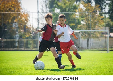 boys  kicking football on the sports field