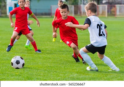 boys kicking football on the sports field