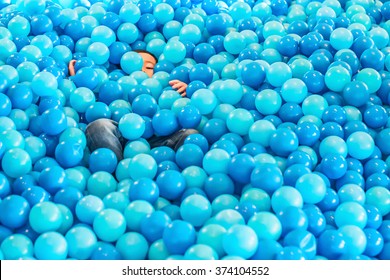 The boys lie embedded in piles plastic balls.