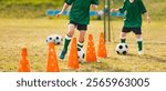 Boys on soccer football training camp. Young players dribble ball between training cones. Soccer summer training camp. Players on football practice session