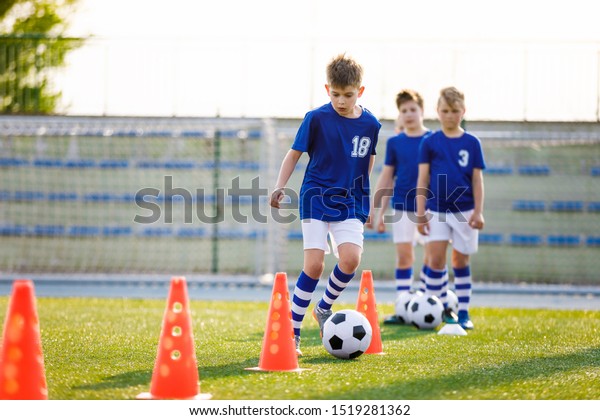 Boys on Sports Training.\
Football Training Dribbling Cone Drill. Young Boys of School Junior\
Soccer Team Practicing on Grass Field. Kids Improving Football\
Skills