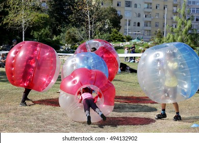Boys are playing bubble football game in the park.