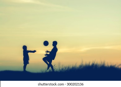 Boys Playing Football At Sunset. Silhouette Concept