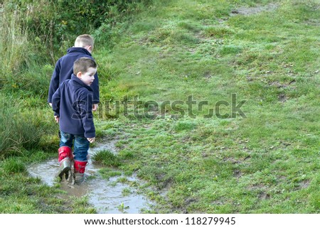 Boys playing in a muddy puddle