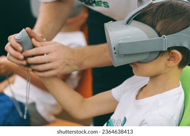 Boys playing video game on virtual reality simulator at home - Shutterstock ID 2364638413