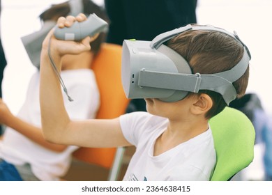 Boys playing video game on virtual reality simulator at home - Shutterstock ID 2364638415