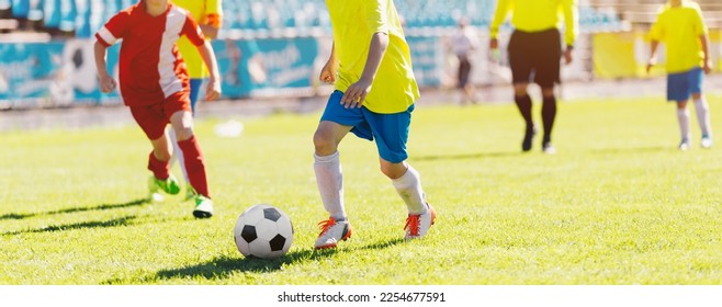 Boys Running and Kicking Football. Football Soccer Match for Children. Kids Playing Soccer Tournament Game. Soccer Stadium in the Background - Shutterstock ID 2254677591