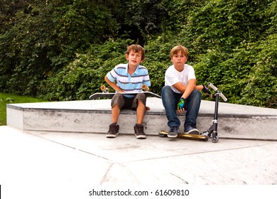 boys are sitting at a box in the skate park and relaxing from skating and scooting - Powered by Shutterstock