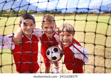 Boys, soccer player and ball on goal net, smile and happy for game, field and child. Outdoor, playful and sport for childhood, portrait and athlete for match, alone and outside on football pitch - Powered by Shutterstock