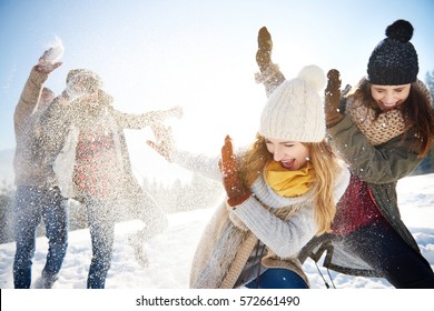 Boys throwing snowballs right on the girls