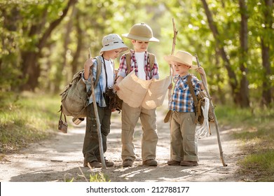 Boys travelers with backpacks studying the route map in a sunny summer day