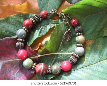 The bracelet of beads on autumn leaves.