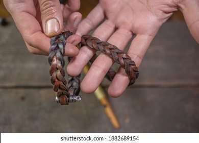 Bracelet leather handicraft. Pigtail accessory. Man s hands making handicraft leather on beautiful old wood background. Polishing tool handmade. - Powered by Shutterstock