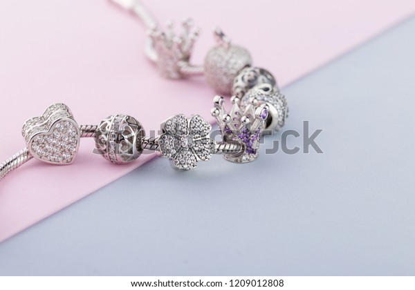 Bracelet with silver\
charm beads with gems. Flower, crown, ball, heart beads.  Product\
concept for jeweler