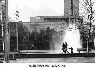 Bradford, West Yorkshire, UK.1.18.2020.Family Walking By The Water Fountains Of The City Centre In Centenary Square.
