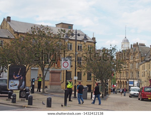 bradford, west\
yorkshire, united kingdom - 19 june 2019: police community support\
officers talk to people outside old buildings and shops in oastler\
square in bradford west\
yorkshire