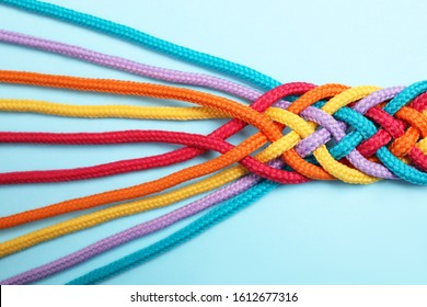 Braided Colorful Ropes On Light Blue Background, Top View. Unity Concept