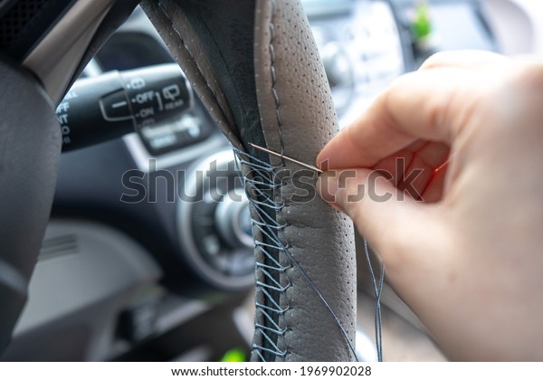 Braided steering wheel with leather cover. The\
mechanic change a new cover of the steering wheel of the car.\
Renewal of steering wheel\
cover.