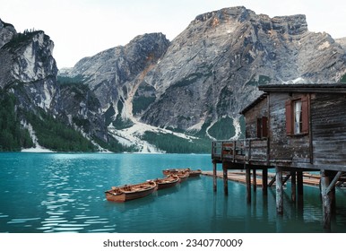 Braies Lake in the Dolomites mountains with forest trail in the background, Sudtirol, Italy. Lake Braies is also known as Lago di Braies. The lake is surrounded by a forest that is famous for its pict
