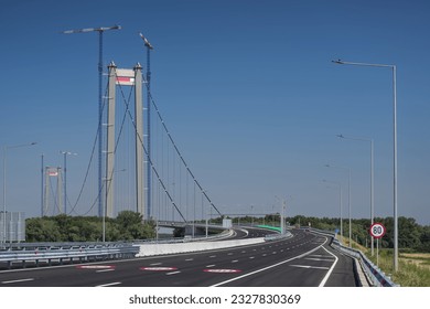 Braila, Romania: Landmark suspension bridge from Braila during a beautiful sunny day with blue sky. Transportation industry in Romania. - Powered by Shutterstock