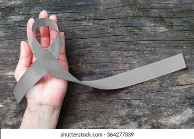 Brain cancer awareness with grey ribbon on helping hand (isolated with clipping path) symbolic bow color for Allergies, Alpha-1 Antitrypsin Deficiency, Aphasia, Asthma, Borderline Personality Disorder