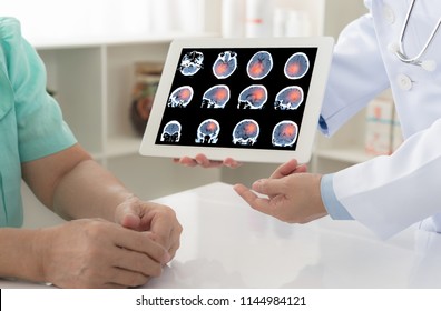 Brain Cencer Or Stoke. Doctor Explaining Results Check Up Of Brain X-ray Scan On Digital Tablet Screen To Patient.