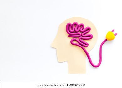 Brain charging and mental rest. Plug and cable leads to plastiline meanders on white background top view copy space