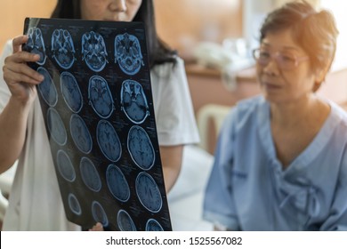 Brain Disease Diagnosis With Medical Doctor Diagnosing Elderly Ageing Patient Neurodegenerative Illness Problem Seeing Magnetic Resonance Imaging (MRI) Film For Neurological Medical Treatment