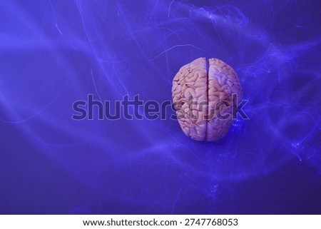 Brain model generating neural impulses on blue background