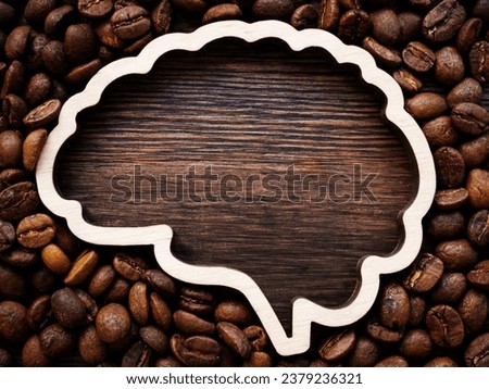 Brain outline with space for inscription surrounded by roasted coffee beans for energy and cheerfulness.