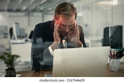 Brain Overload. Shot Of A Businessman Looking Stressed While Working At His Laptop.